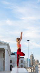 Portrait of a mature woman, 59 years old, doing yoga on a city street. Sports in the life of a...