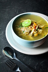 soto ayam, soto ayam or chicken soto is indonesian traditional food. top view in dark and texture background. soto ayam kudus.