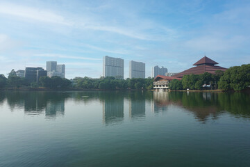 Fototapeta premium some apartment building in the distance and a building next to a lakesore in University of Indonesia