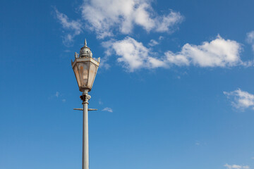 Fototapeta na wymiar Antique street lamp with openwork ornament against the sky