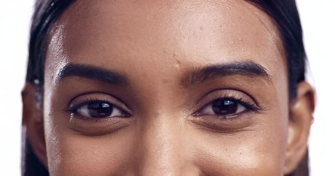 Portrait, eyes and vision with a woman closeup in studio isolated on a white background looking happy. Face, beauty and eyesight with a young model posing to see her eyebrows for natural skincare