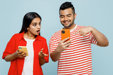 Young shocked couple two friends family Indian man woman wear red casual clothes t-shirts together...