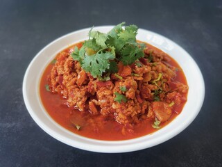 Nam Prik Ong, northern Thai food sauteed with ground pork, tomatoes and chili isolated on black background.