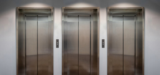 Elevators lobby, Stainless steel lifts with closed doors front view.