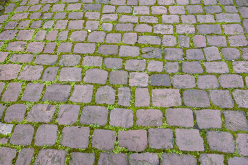 Stone paved floor background texture. Cobblestone grey footpath above view