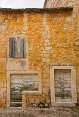 Fototapeta na wymiar An abandoned house in Sutivan, Brac Island, Croatia. The street is paved with traditional kogule or kogulavanje paving. Common in coastal villages in Dalmatia, it uses beach pebbles