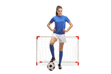 Full length portrait of a female football player posing in front of a mini goal - obrazy, fototapety, plakaty