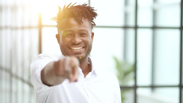 Handsome happy young man pointing at camera