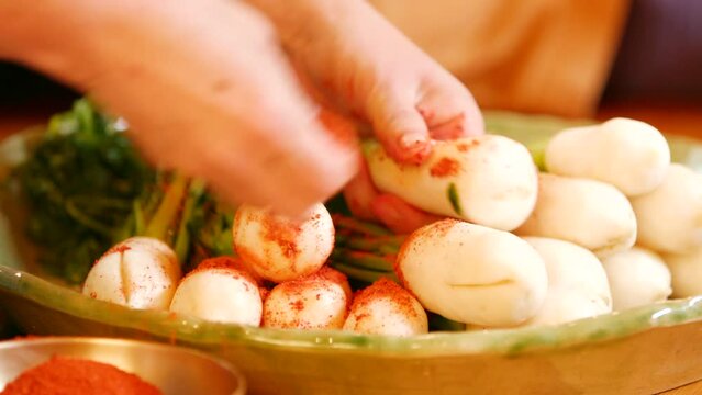 알타리로 총각 김치를 담는 과정. 고추가루로 무에 물을 들이고 양념을 버무리는