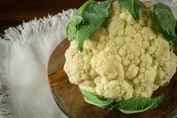 Whole head of the fresh raw cauliflower with some leaves