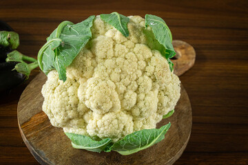 Whole head of the fresh raw cauliflower with some leaves