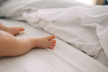 Obraz na płótnie Canvas Soft newborn baby tiny feet against a white blanket.