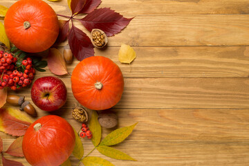 Flat lay with pumpkins, fruits and autumn leaves on wooden background, top view