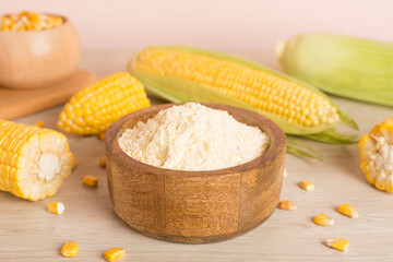 Corn flour with fresh cobs on wooden table
