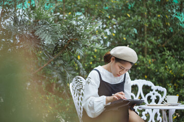 girl sitting on a tablet in the park