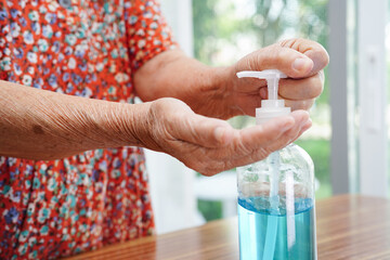 Asian senior woman press blue alcohol sanitizer gel for washing hand protect infection coronavirus.