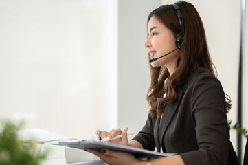 A female call centre operator talking with a customer to resolve their issues over the phone