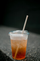 Peach tea in clear glass over black background