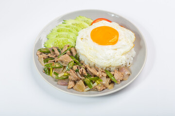Fried pork with green chili, fried egg and cucumber on white background