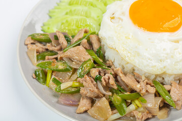 Fried pork with green chili, fried egg and cucumber on white background