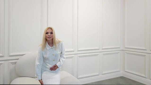 Stylish woman in total white outfit posing