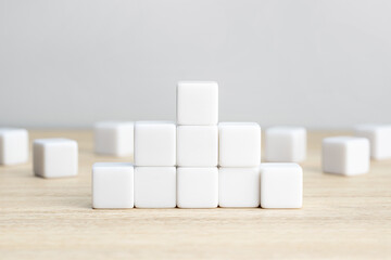 Pyramid of blank white cube blocks on table. Template mockup