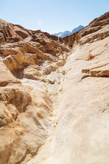 Sinai desert. Yellow and orange sandstone textured carved mountain, bright blue sky. Egyptian desert landscape