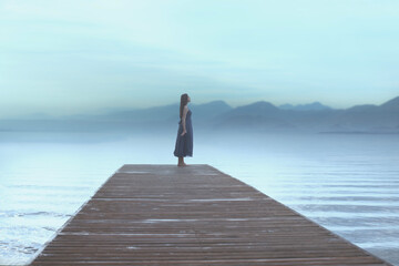 traveler woman looks relaxed at the surreal blue painted view - obrazy, fototapety, plakaty