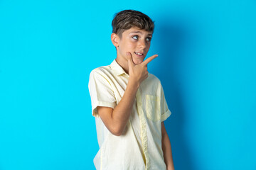 Beautiful kid boy wearing casual shirt Thinking worried about a question, concerned and nervous with hand on chin.