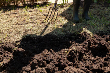 Man digs up land with pitchfork..