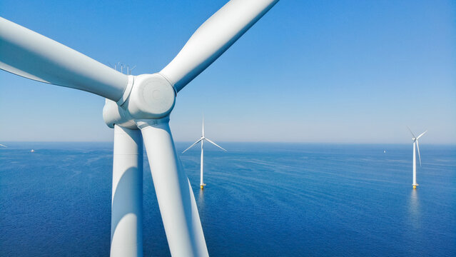 windmill park with clouds and a blue sky, windmill park in the ocean aerial view with wind turbine Flevoland Netherlands Ijsselmeer. Green energy 
