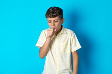 Beautiful kid boy wearing casual shirt feeling unwell and coughing as symptom for cold or...