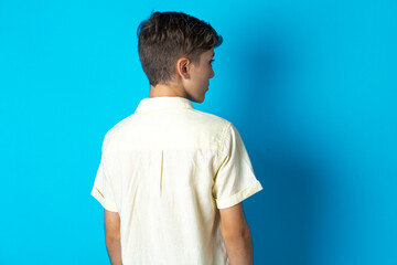 The back side view of a Beautiful kid boy wearing casual shirt . Studio Shoot.