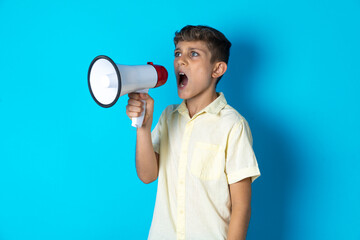 Beautiful kid boy wearing casual shirt Through Megaphone with Available Copy Space