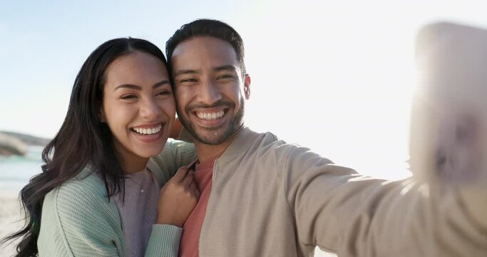 Selfie, peace sign and couple at beach, happy and bonding together on vacation. Wink, interracial man and woman smile in profile picture, memory and travel on holiday at ocean on sunset lens flare