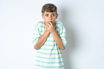 Beautiful kid boy wearing striped casual t-shirt holding oneself, feels very cold outside, hopes...