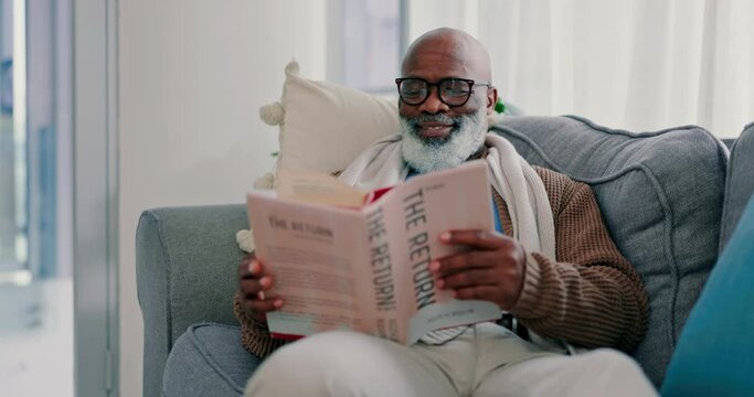 Smile, mature black man and reading book in home on living room sofa. Happy, novel and African person in lounge to relax, study literature and knowledge of fantasy story in retirement hobby in house