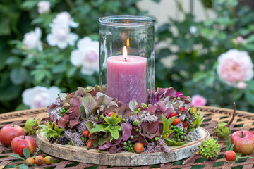florales Sommer-Arrangement mit Blumenkranz und einer Kerze