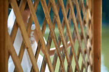 A wooden vintage wall behind which the bride is standing in defocus