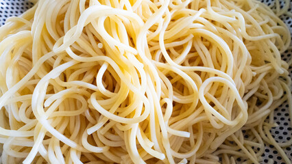 Yellow spaghetti is boiled and prepared for cooking.