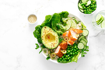 Salmon avocado bowl with broccoli, green peas, rice and fresh salad. Healthy food, top view