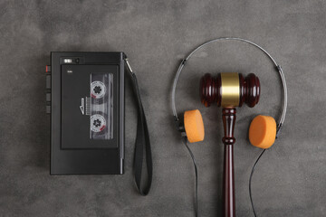Music piracy and copyright protection law concept, gavel, tape recorder and headphones on table
