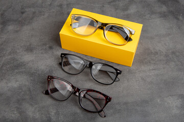 Eye care concept - classic fashion eyeglasses on grey background