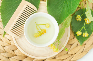Small bowl with homemade linden (tilia, basswood, lime tree) face toner with linden flowers. Natural beauty treatment and spa recipe. Top view.