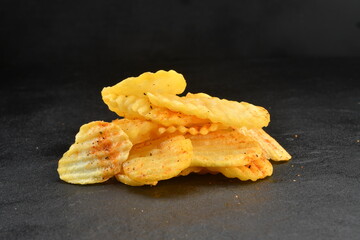 Crispy spicy potato chips isolated
black background