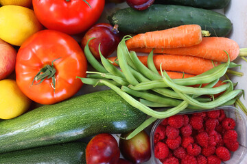 Wooden crate full of healthy colorful seasonal fruit and vegetable. Top view.