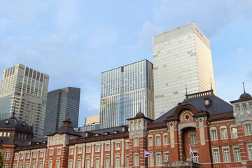 Fototapeta na wymiar Facade of red brick Tokyo central station with modern high buildings