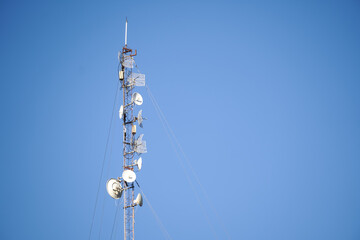 Telecommunication towers include of radio microwave and television antenna system with cloud blue...