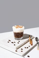 Café irlandés con crema batida y canela sobre fondo gris	
