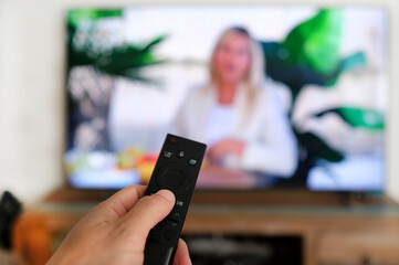 Remote control and screen - watching the favorite TV show